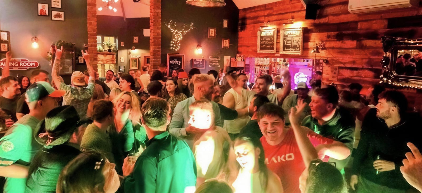 A packed crowd with hands in the air during a live music night