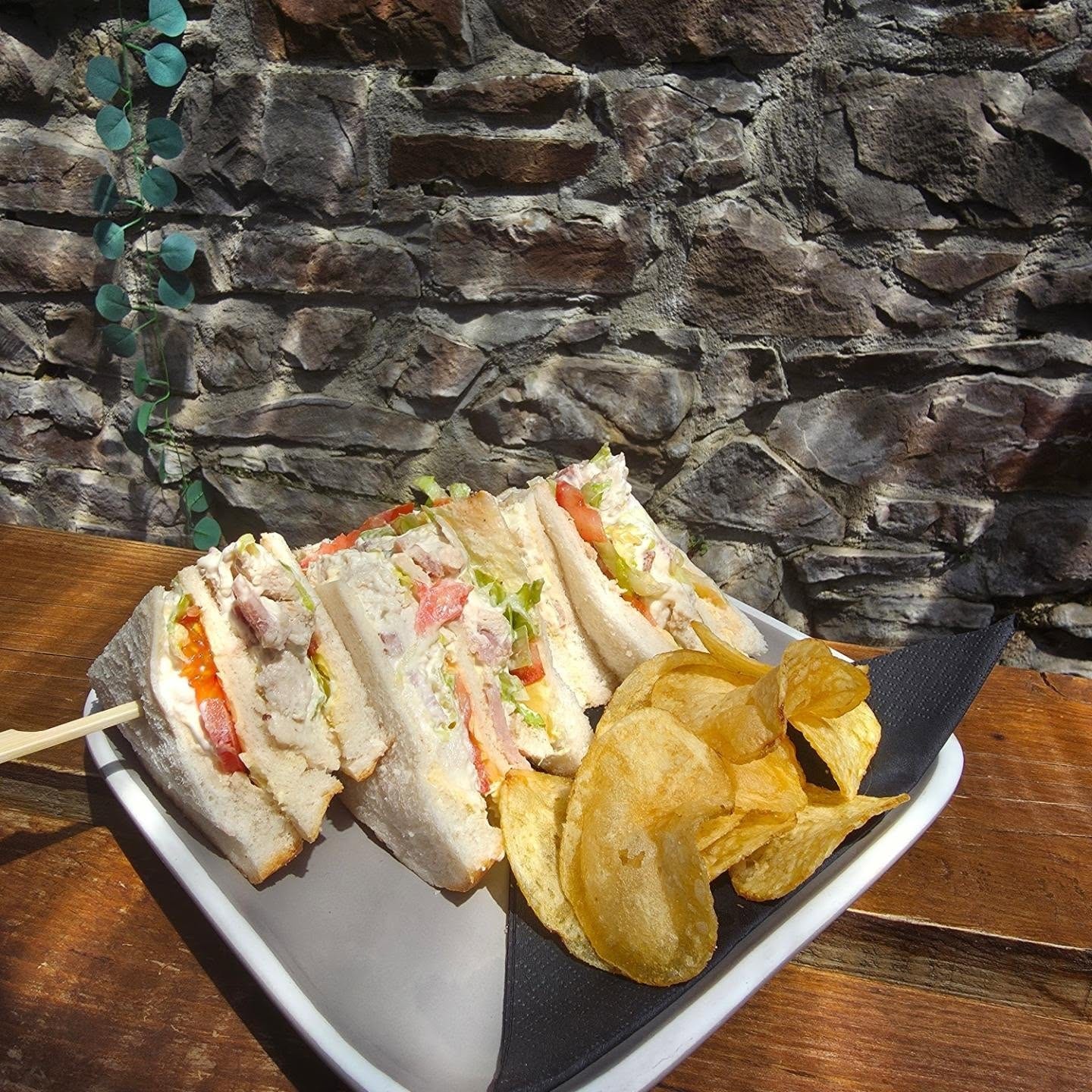 Classic club sandwich with kettle chips served in the sunny courtyard at Bar Thirty Five Bude